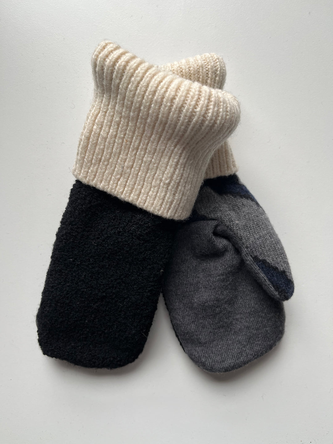 Black, grey, and cream mittens with blue pattern