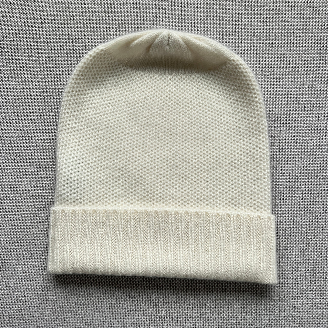Basket weave slouchy beanie with a ribbed cuff in cream.